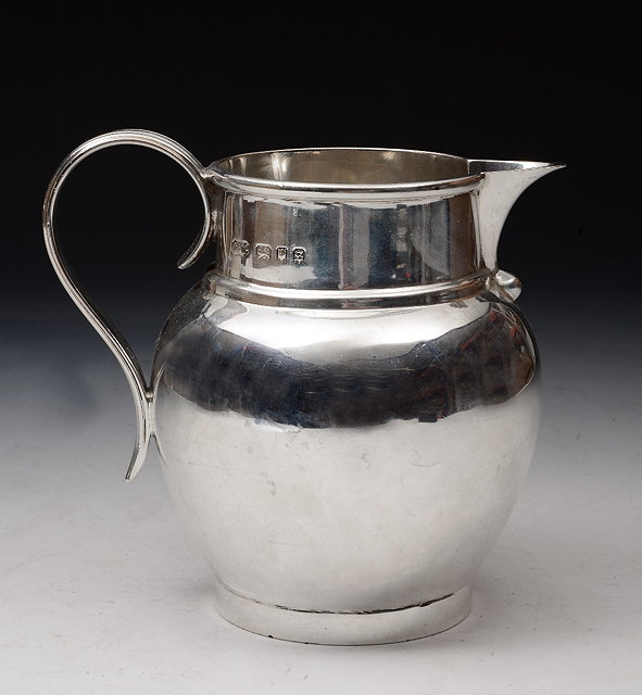 Appraisal: A SILVER BALUSTER SHAPED CREAM JUG with reeded scroll handle