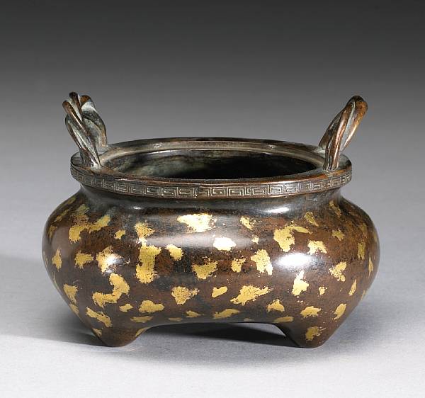 Appraisal: An archaistic 'sunspot' bronze censer Its base bearing a square-sectioned