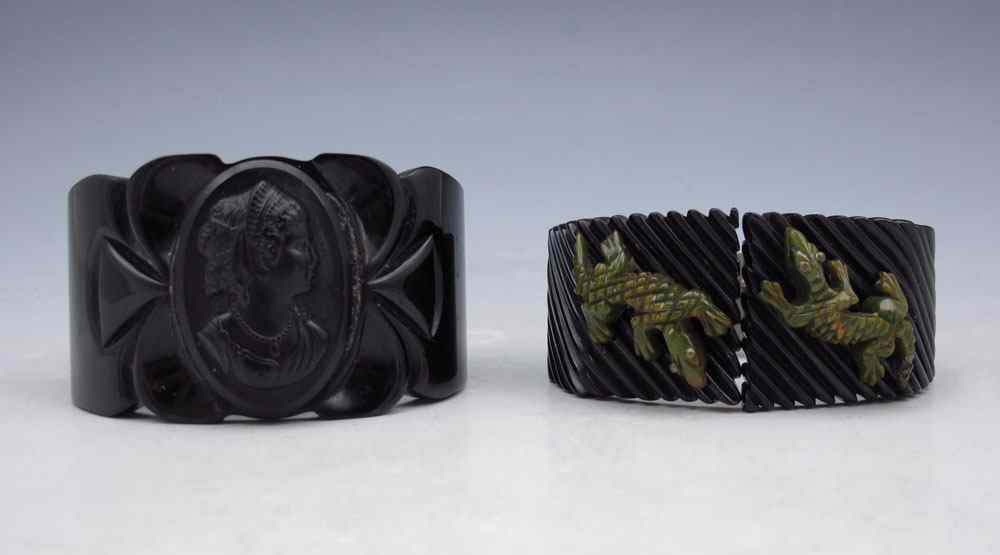 Appraisal: TWO VINTAGE BLACK BAKELITE HINGED BANGLE BRACELETS Carved Bakelite bangle