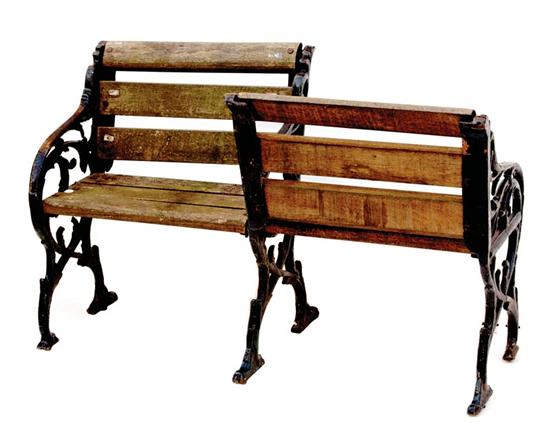 Appraisal: Cast-iron and wood conversation seat scrolling supports unified by wood