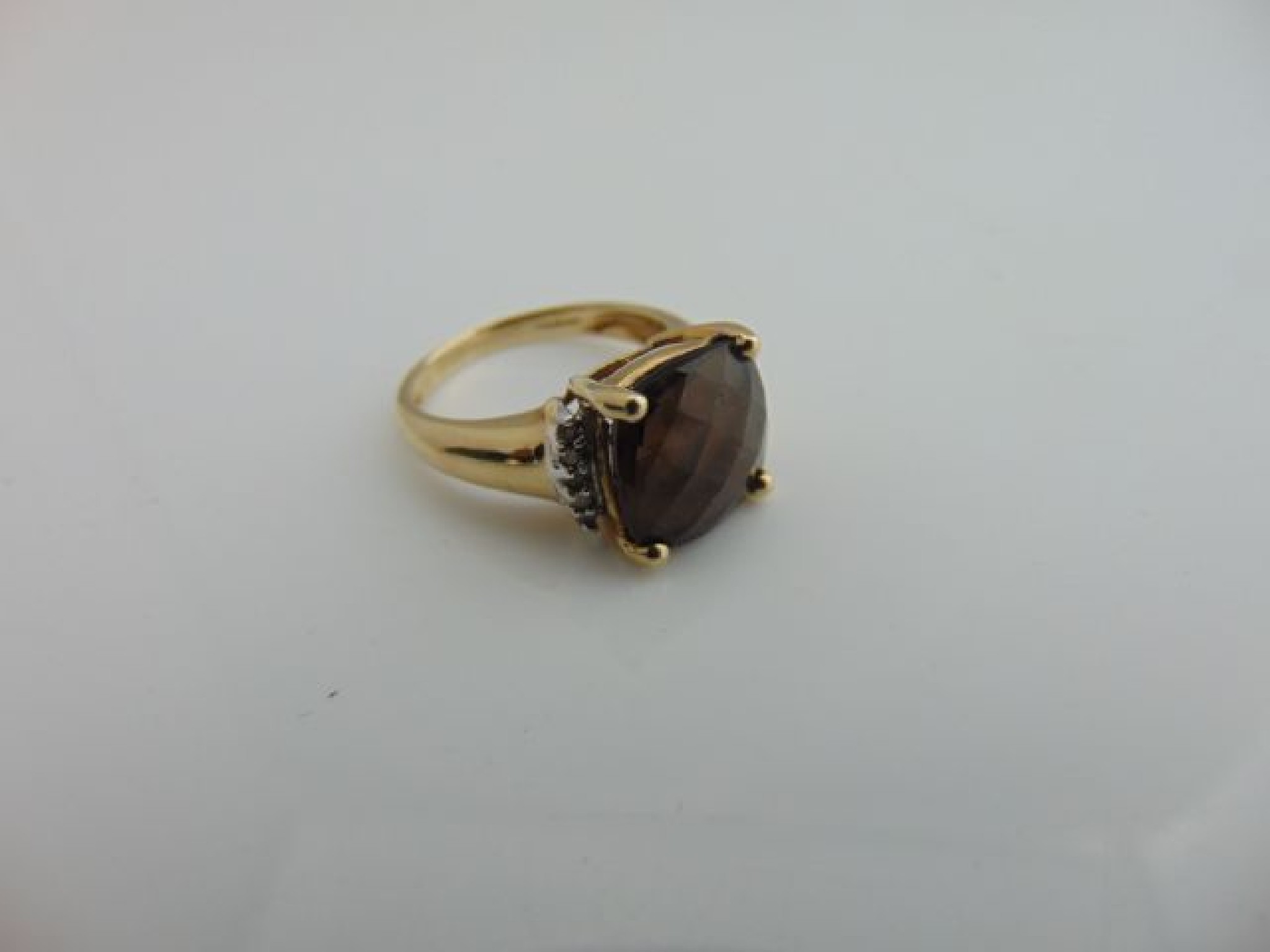 Appraisal: A smoky quartz ring centred with a cushion shaped briolette-cut