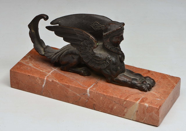 Appraisal: AN EGYPTIAN REVIVAL BRONZE SPHINX on a rouge marble plinth