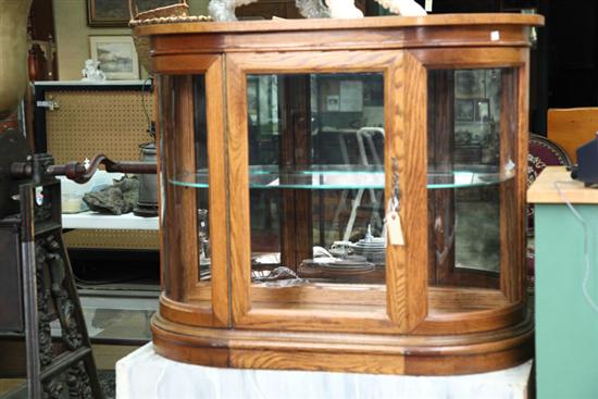 Appraisal: CONTEMPORARY DISPLAY CASE Oak with a glazed door curved glass