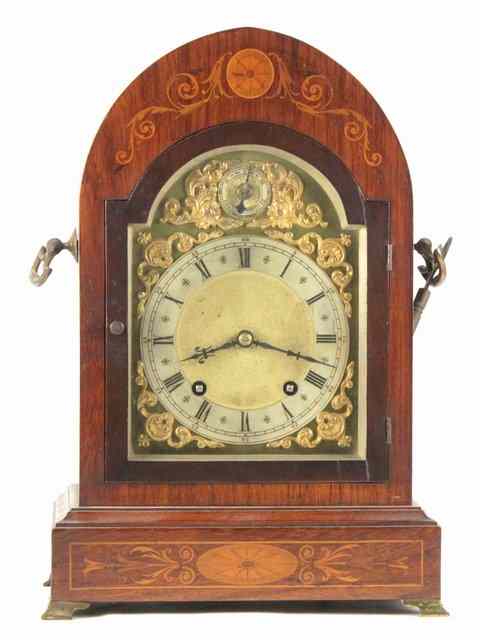 Appraisal: An Edwardian eight-day mantel clock in an arch top inlaid