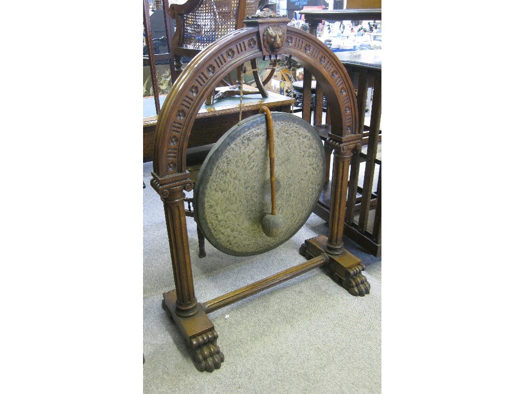 Appraisal: Dinner gong in carved oak stand on hairy paw feet