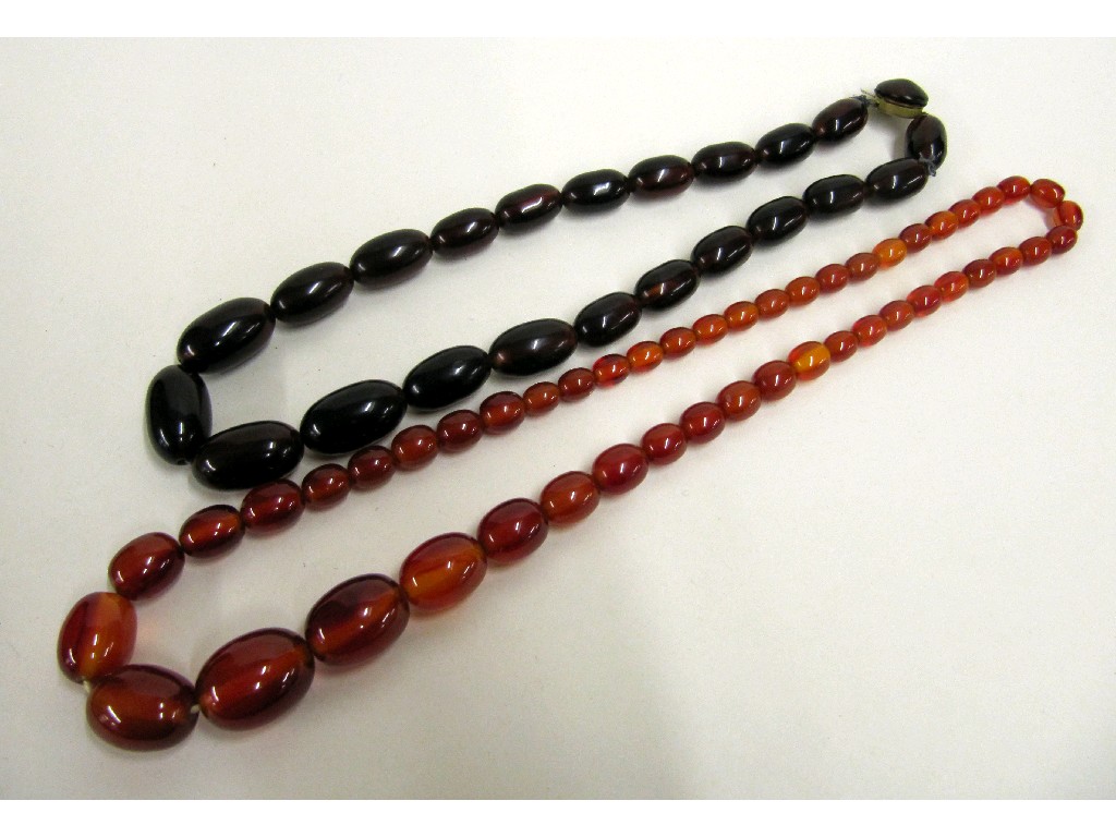 Appraisal: Two strings of amber coloured beads