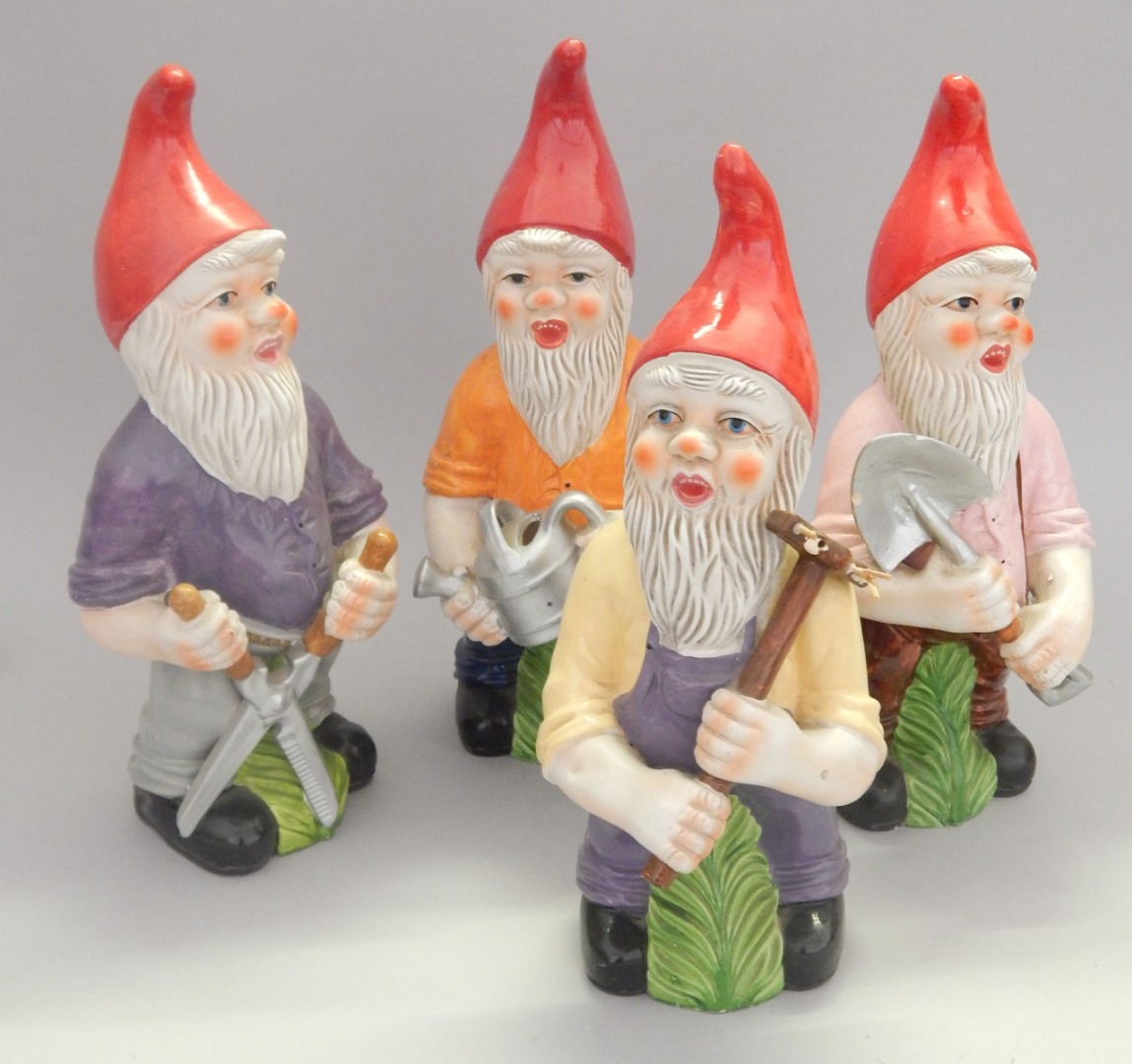 Appraisal: A set of four painted composition garden gnomes each carrying