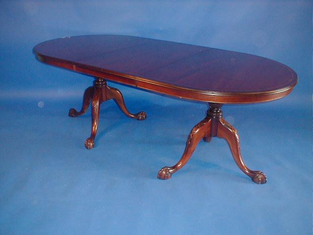 Appraisal: A reproduction cross banded mahogany twin pillar dining table with