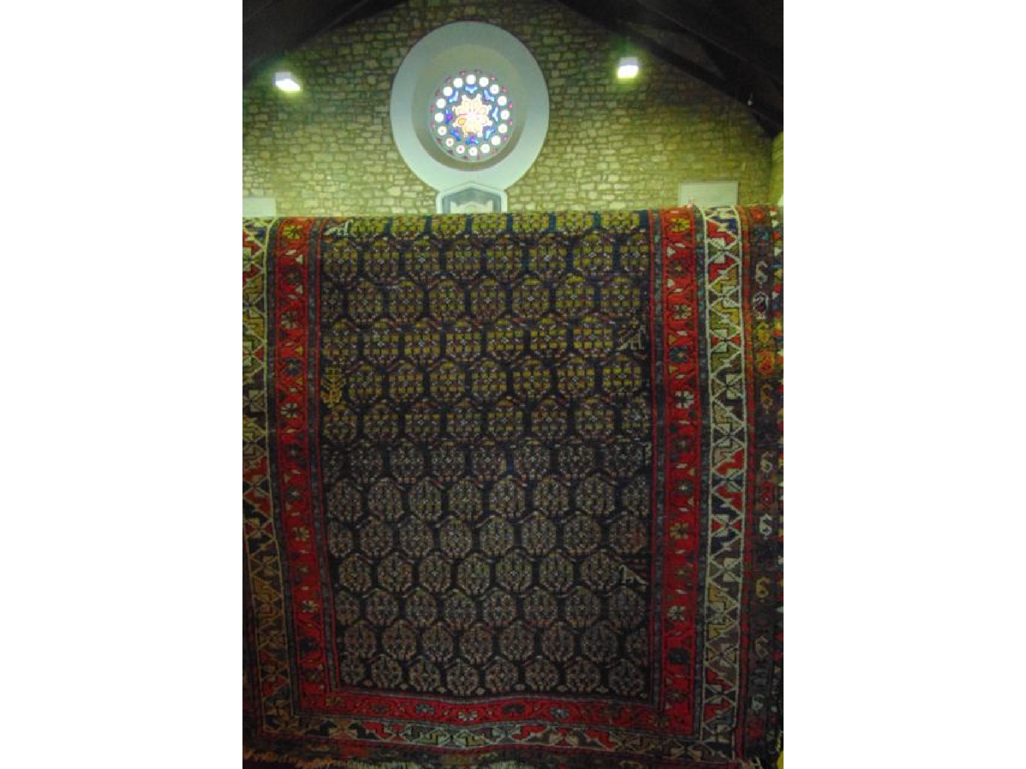 Appraisal: An eastern wool work rug with multi medallion centre in