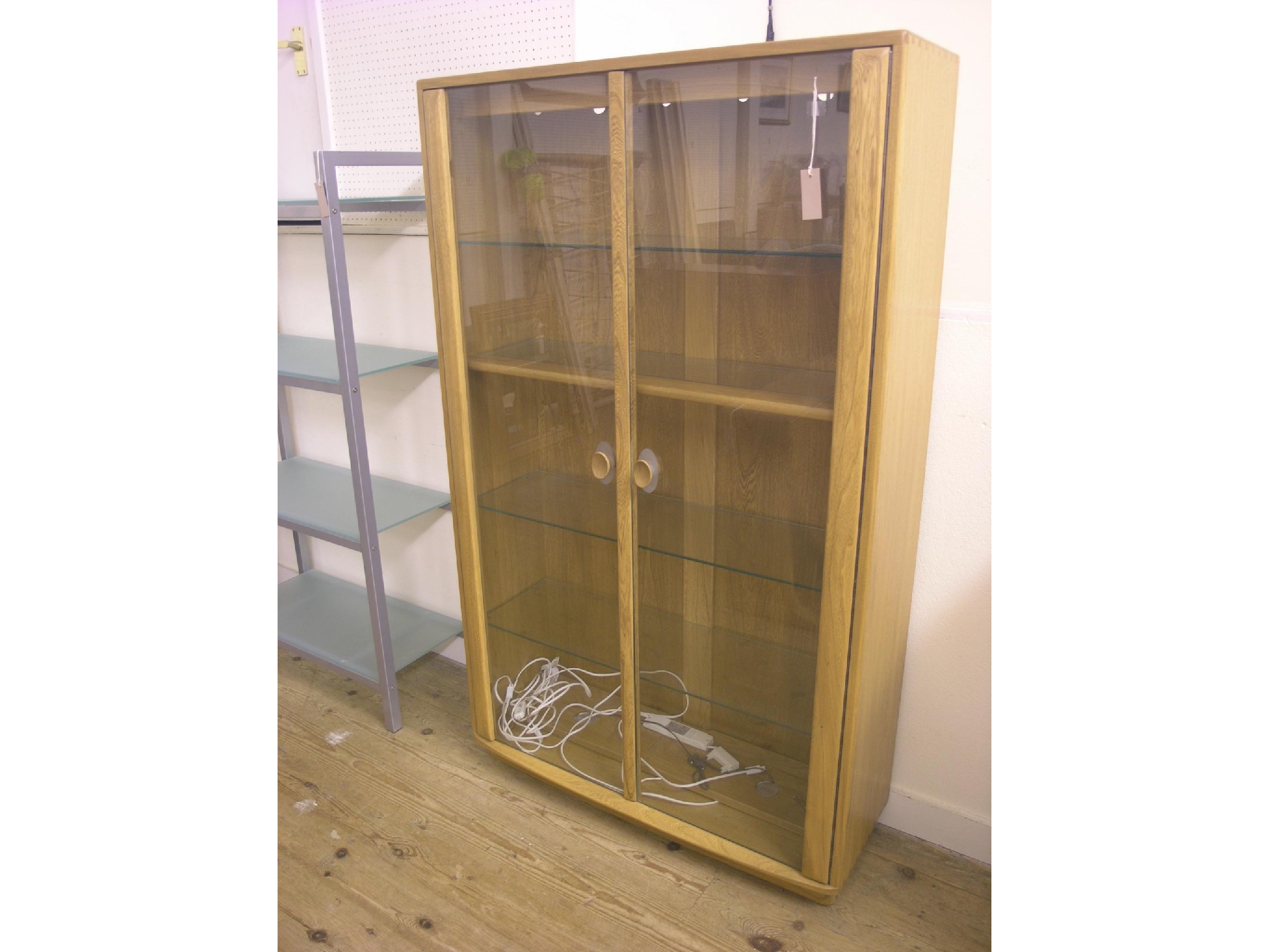 Appraisal: An Ercol light elm display cabinet plate glass shelves enclosed