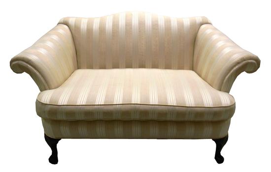 Appraisal: Cream colored upholstered loveseat camel back with rolled armrests single