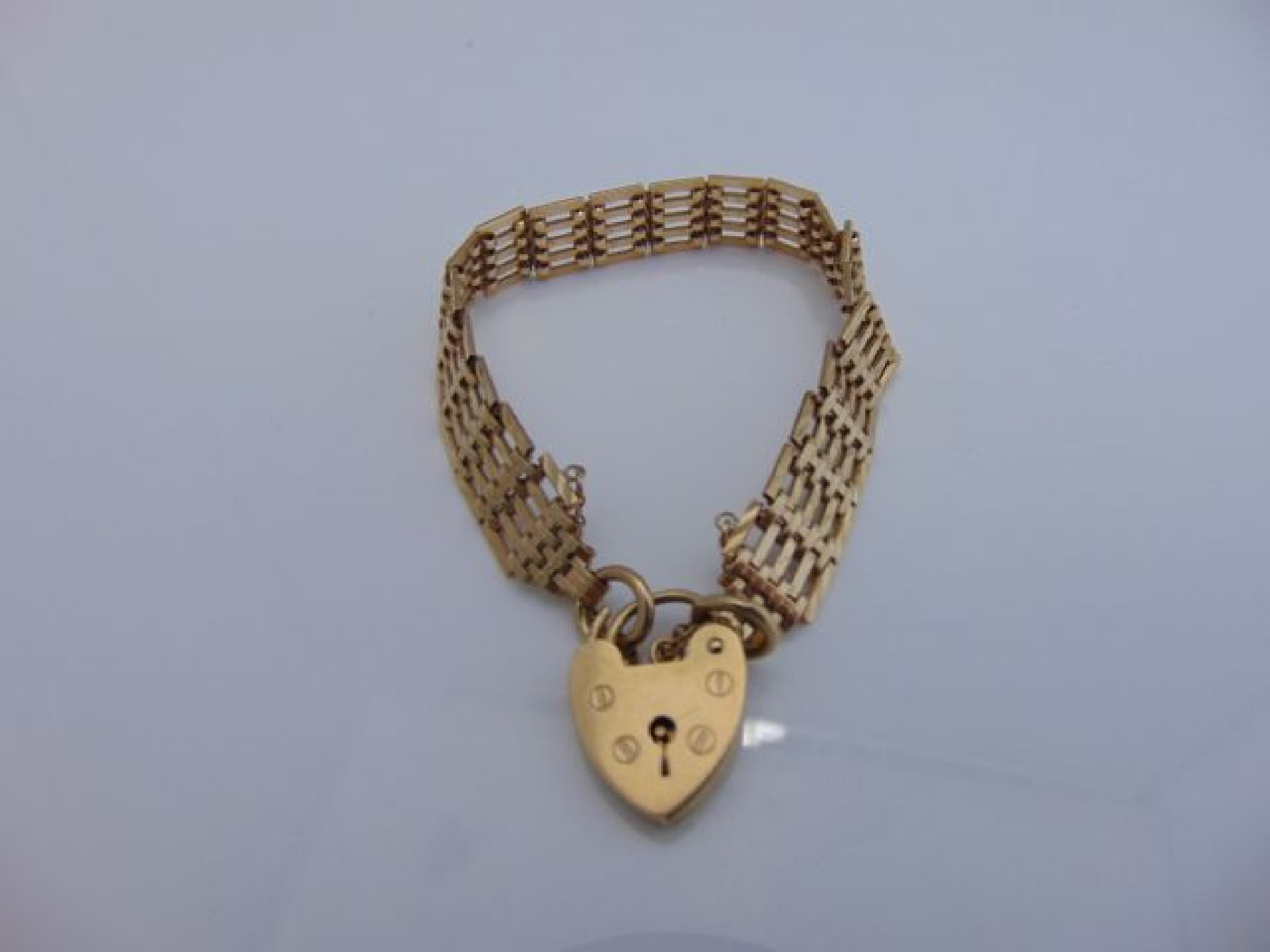 Appraisal: A ct gold gate-link bracelet JAM with heart-shaped padlock clasp