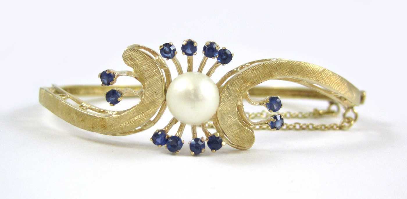 Appraisal: SAPPHIRE PEARL AND FOURTEEN KARAT GOLD BANGLE The oval hinged