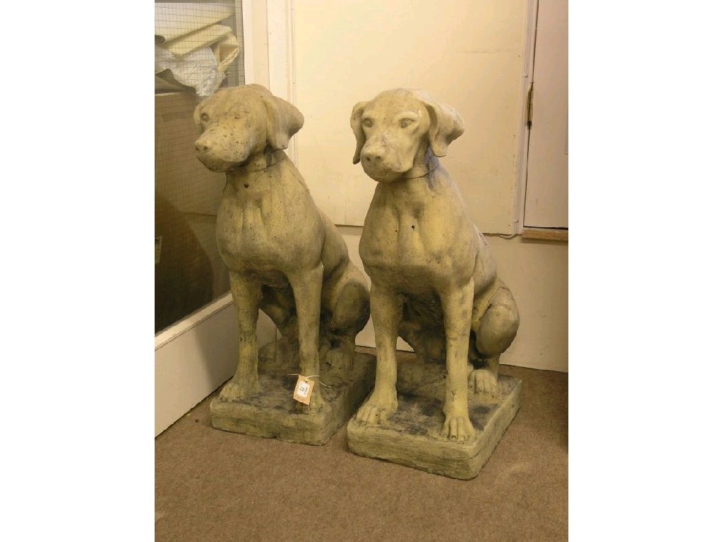 Appraisal: A pair of moulded concrete garden dogs each recumbent on