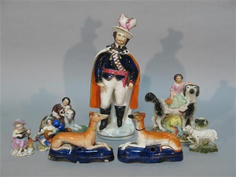 Appraisal: TWO STAFFORDSHIRE GREYHOUNDS Recumbent as inkstands together with a group