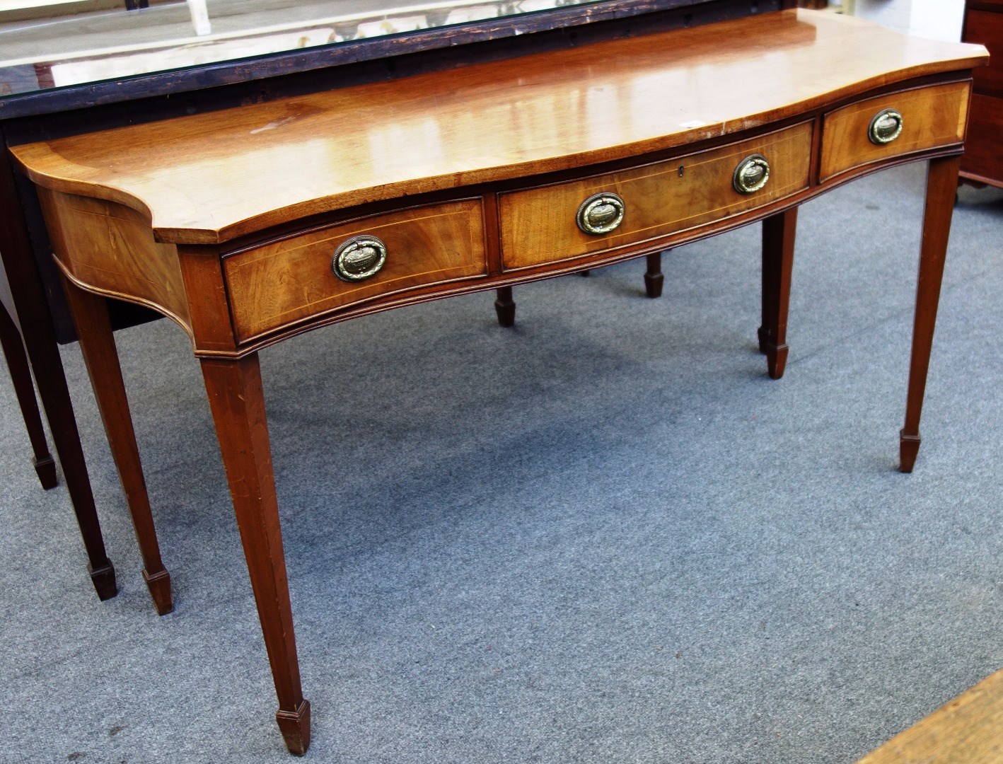 Appraisal: A late th century mahogany serpentine three drawer serving table