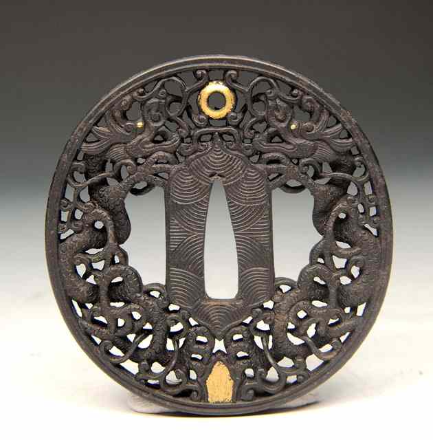 Appraisal: A JAPANESE CAST IRON AND GILT TSUBA decorated with intertwined