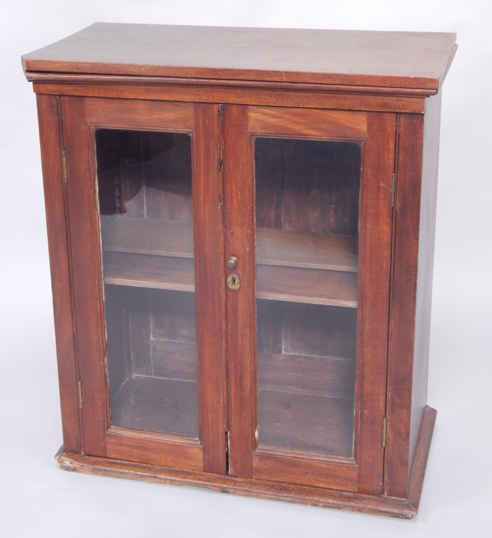 Appraisal: A mahogany bookcase with two glazed doors enclosing shelves raised