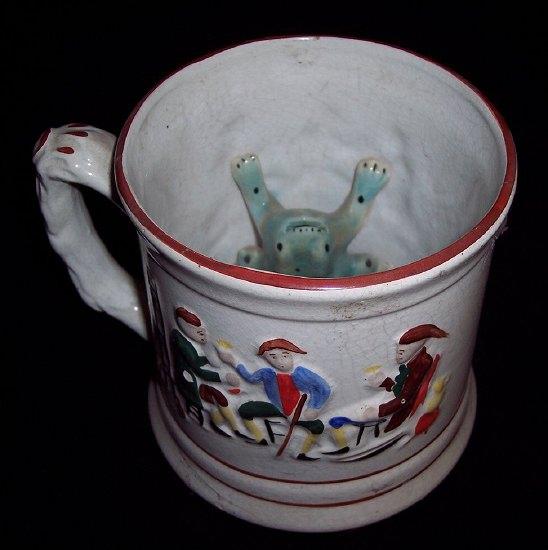 Appraisal: A Staffordshire frog mug painted three figures in an interior