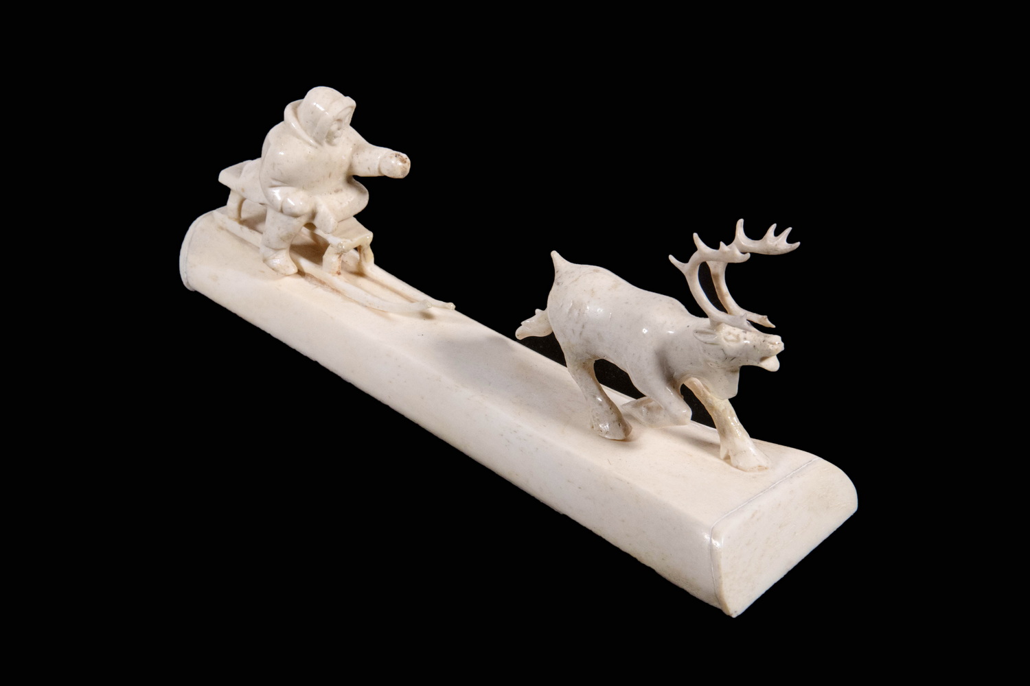 Appraisal: INUIT CARVED BONE MAN ON SLED WITH REINDEER th c