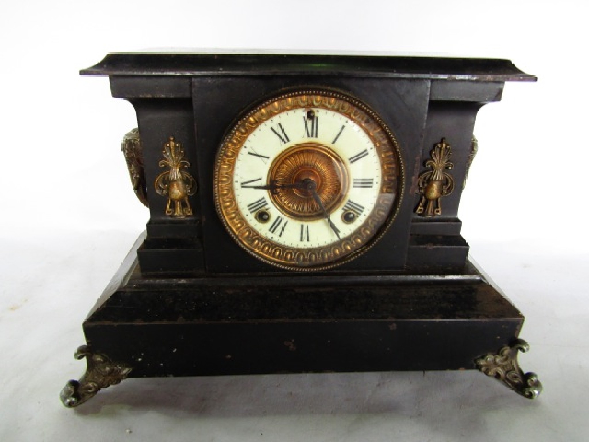 Appraisal: A Victorian cast iron mantle clock to simulate slate with