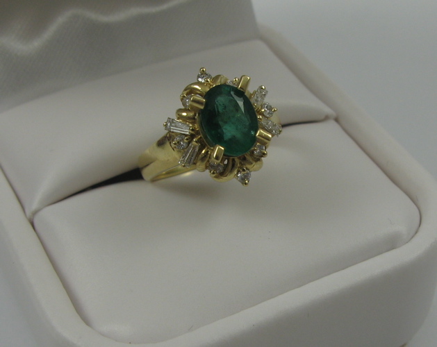 Appraisal: EMERALD DIAMOND AND K GOLD RING centering an oval-cut green