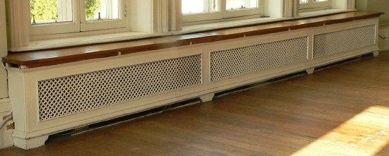 Appraisal: A triple panelled pierced cast radiator surround with wooden top