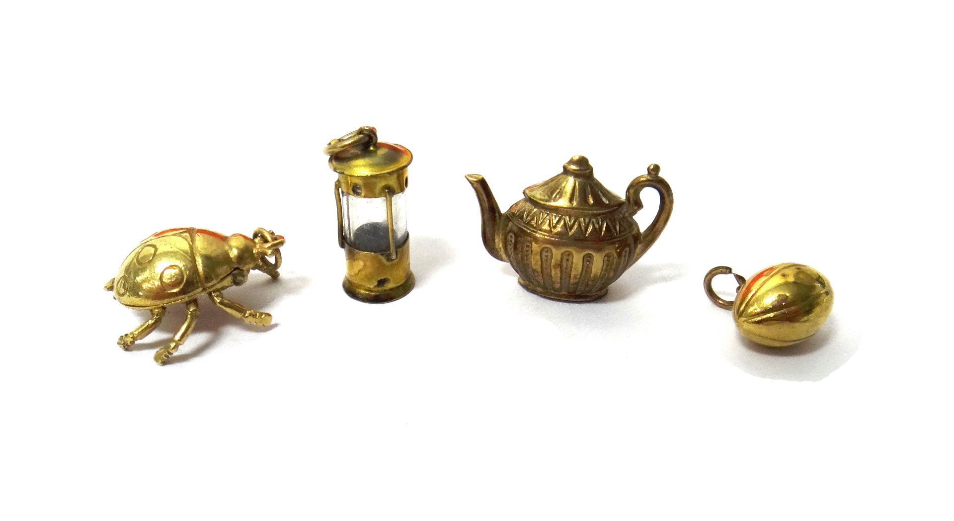 Appraisal: Four ct gold charms comprising a teapot a ladybird a