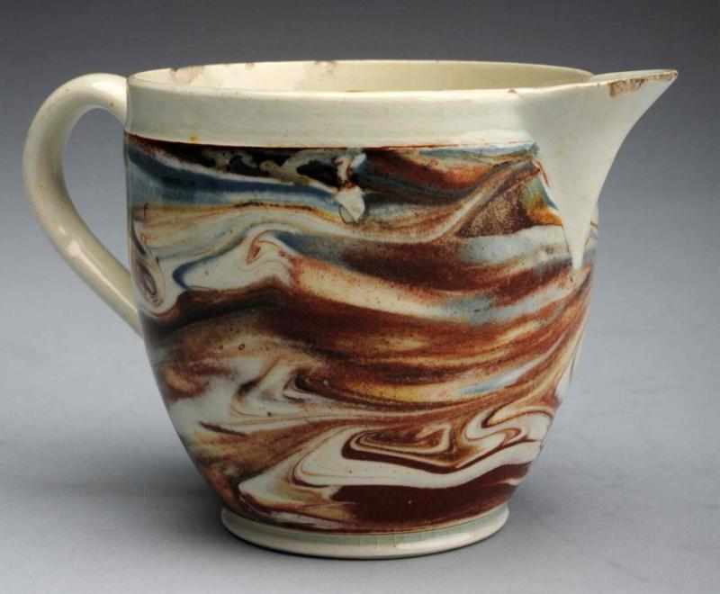 Appraisal: Extremely Unusual Form Mochaware Creamer Early th century Swirl-decorated creamer