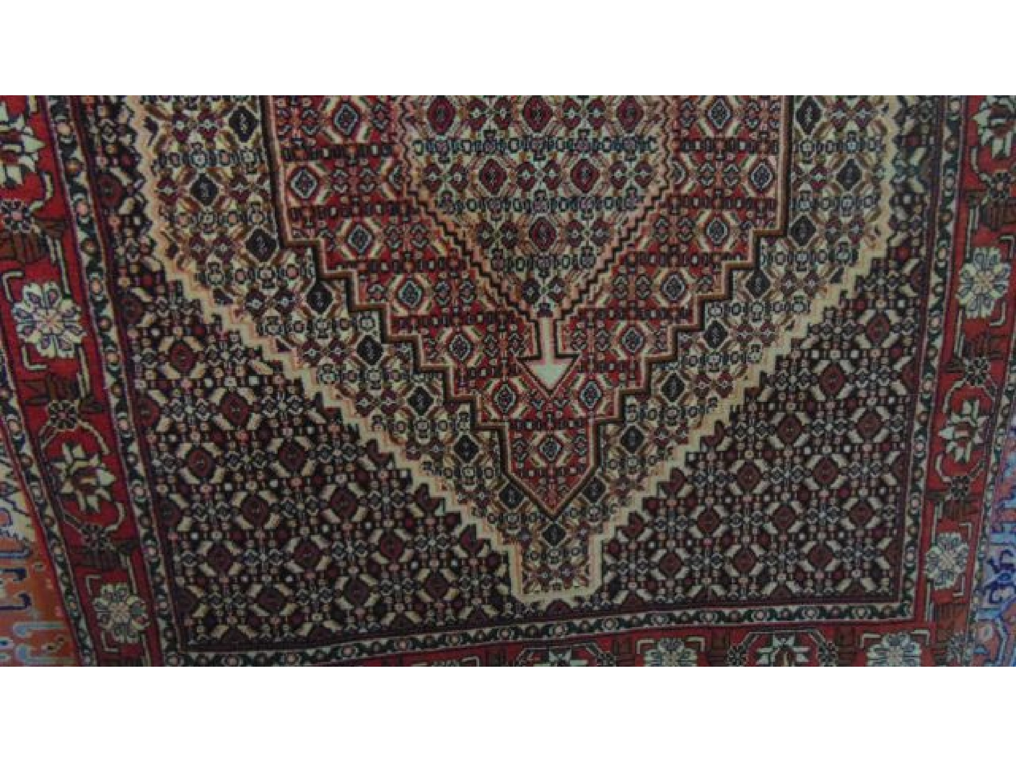 Appraisal: A Persian style carpet with complicated symmetrical medallion detail in