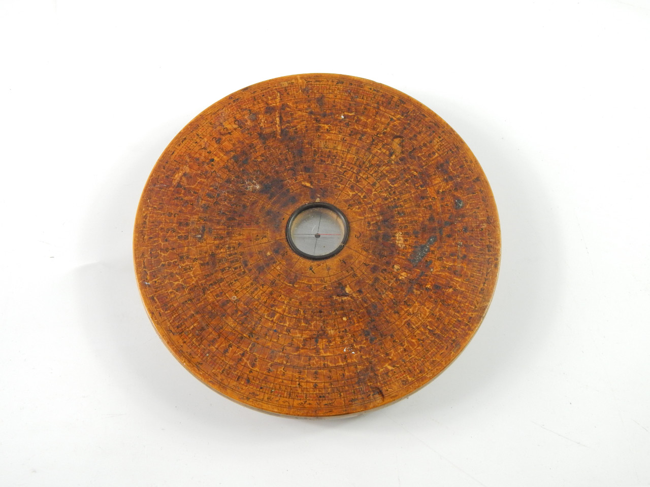 Appraisal: A Chinese calibrated geomancer's compass wooden circular casing with ink