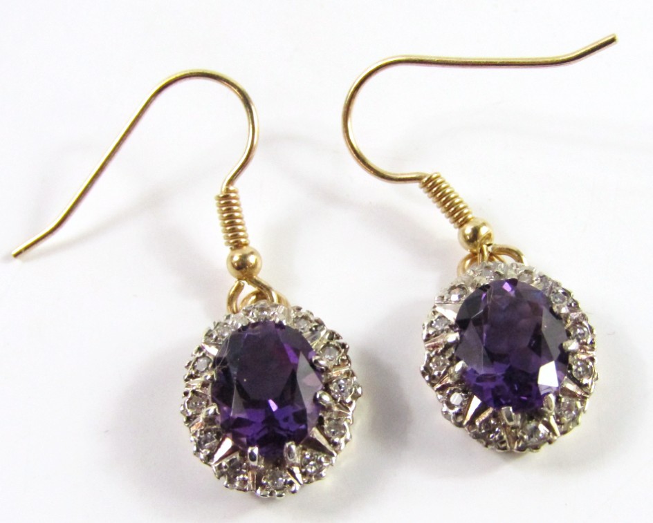 Appraisal: A pair of amethyst and diamond oval cluster drop earrings