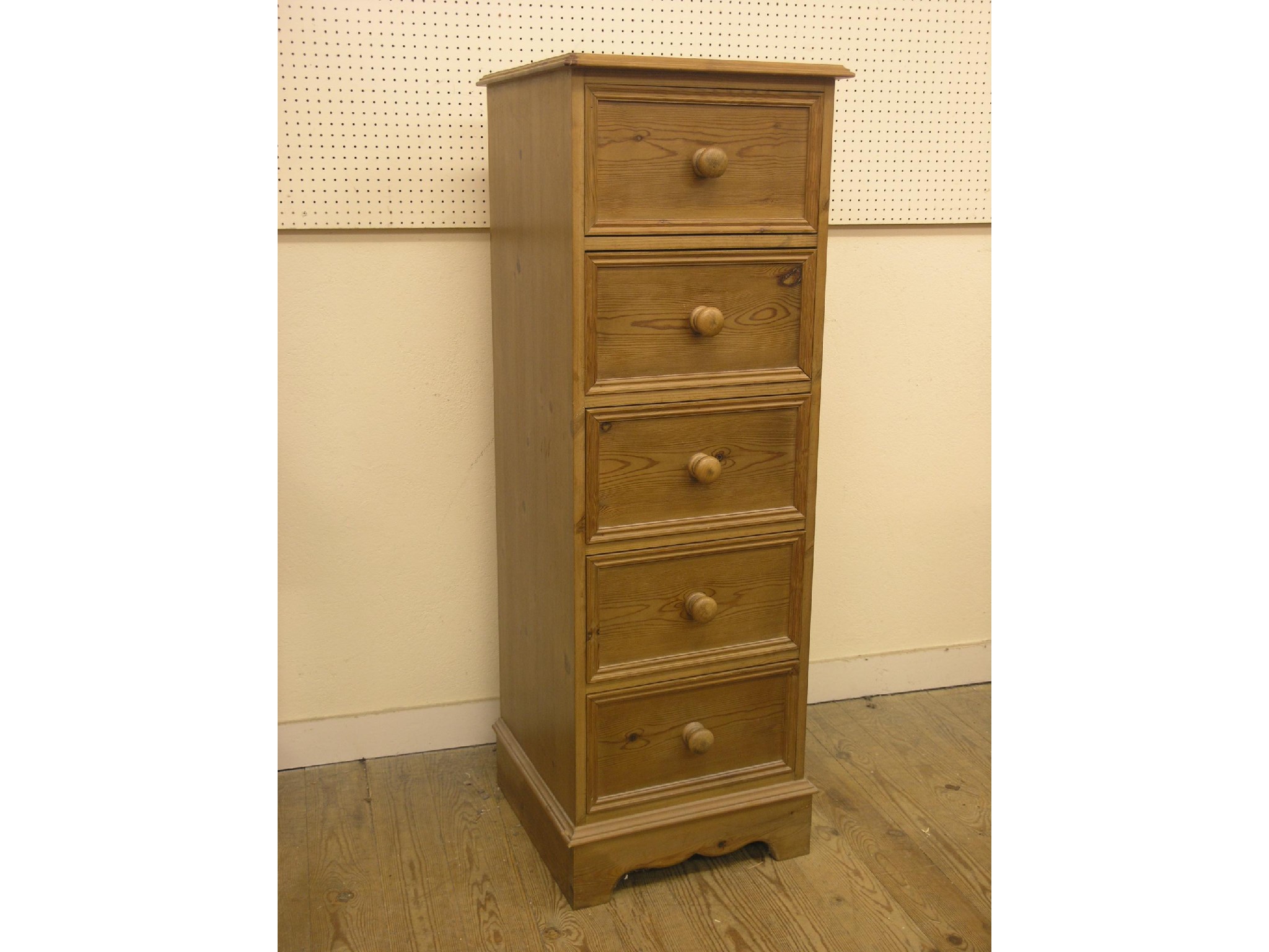 Appraisal: A narrow waxed pine chest five short drawers turned wood