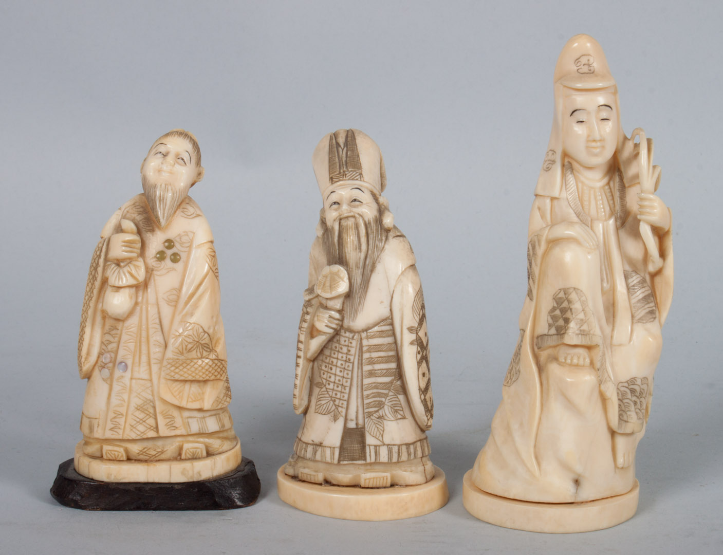 Appraisal: Three Japanese carved ivory sages each modeled as robed figure