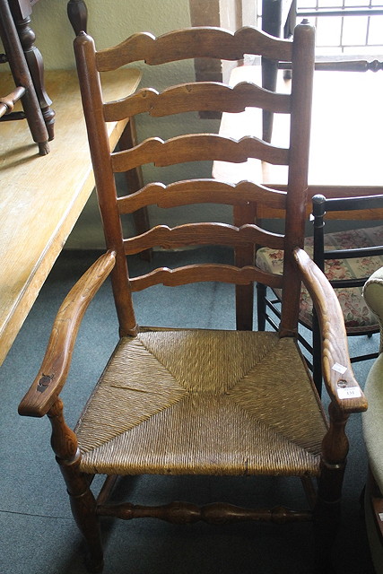 Appraisal: A TH CENTURY OAK LADDERBACK ELBOW CHAIR with rush seat