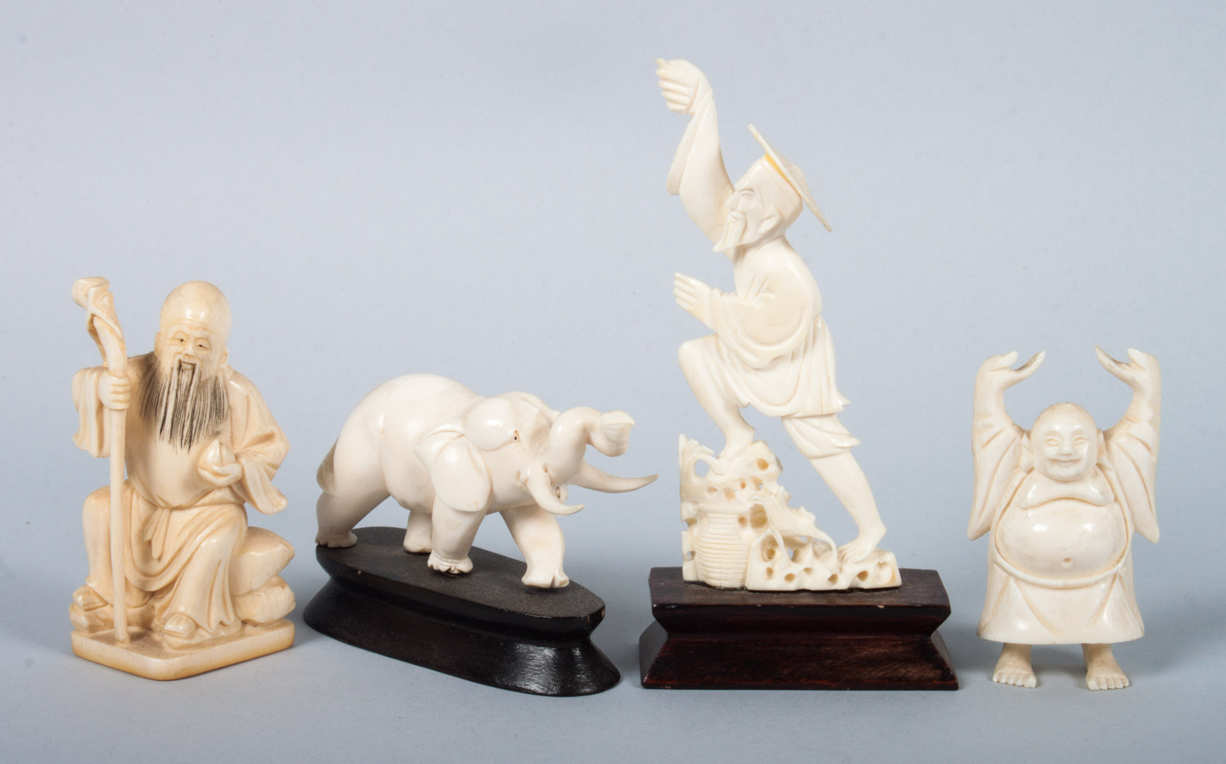 Appraisal: Four oriental carved ivory figures including sage Hotai fisherman mounted