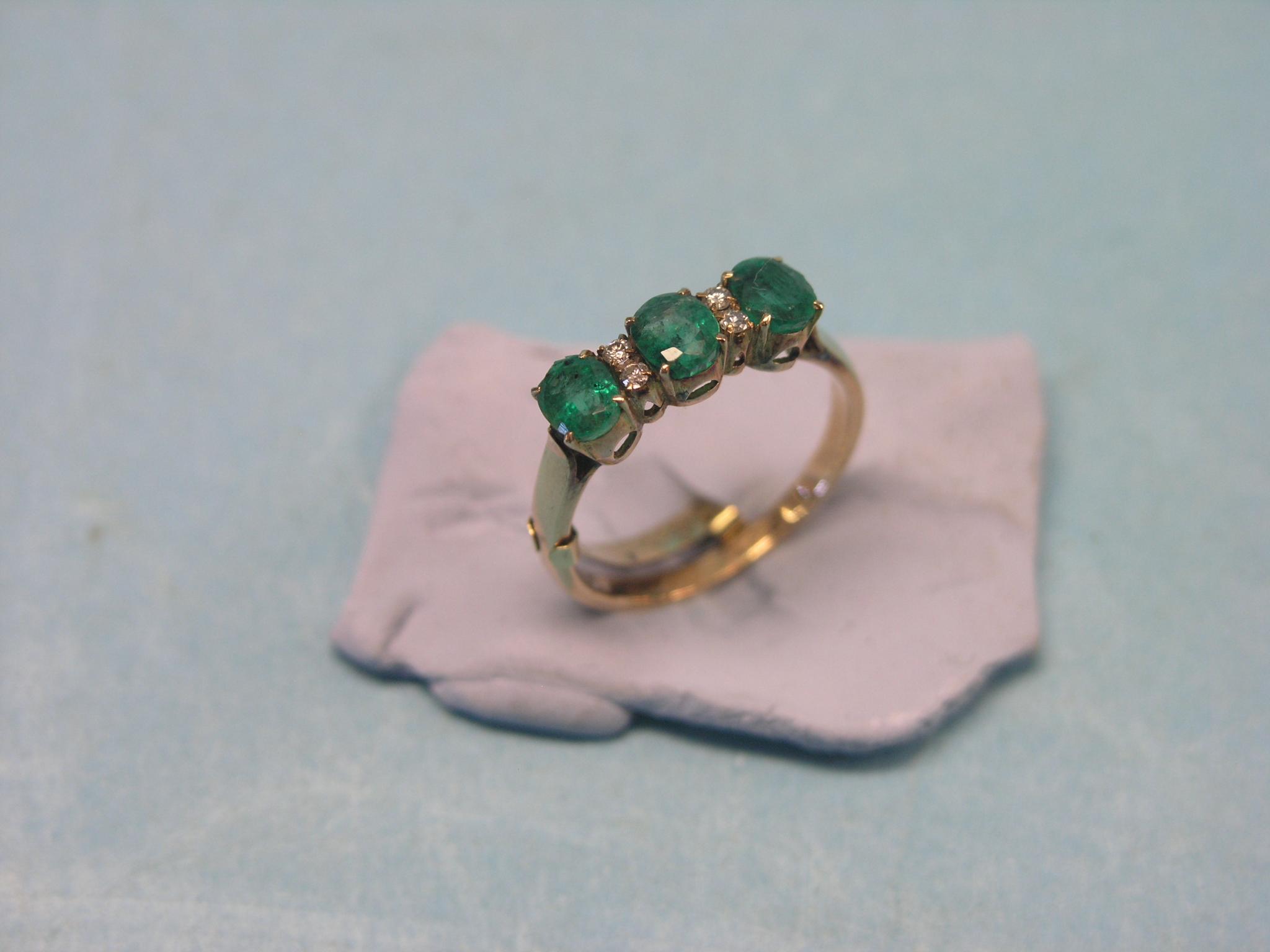 Appraisal: An emerald and diamond-chip ring three claw-set emeralds unmarked yellow