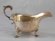 Appraisal: A heavy silver sauce boat with leaf capped flying C