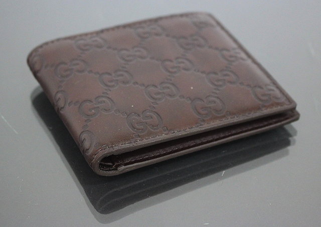 Appraisal: A GUCCI GENTLEMAN'S BROWN LEATHER WALLET with Gucci symbols impressed