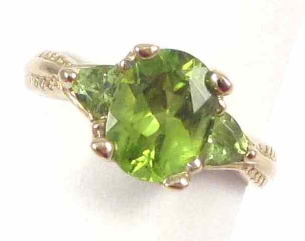 Appraisal: PERIDOT AND FOURTEEN KARAT GOLD RING Two trillion-cut peridots are