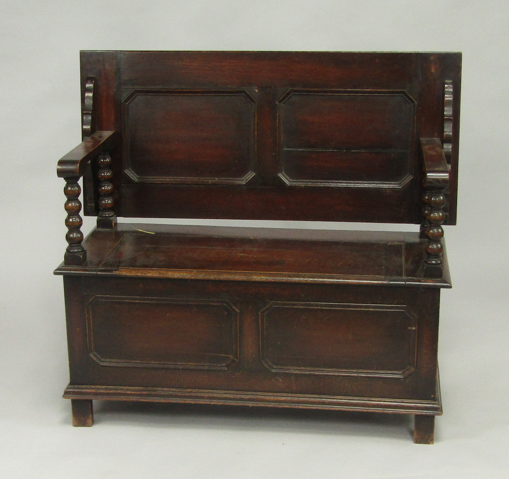 Appraisal: An oak monks bench the panelled top raised on bobbin