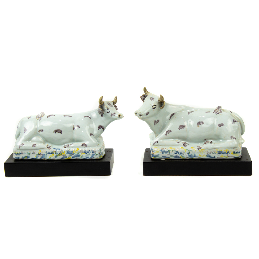 Appraisal: A PAIR OF FRENCH FAIENCE MODELS OF RECUMBENT COWS A