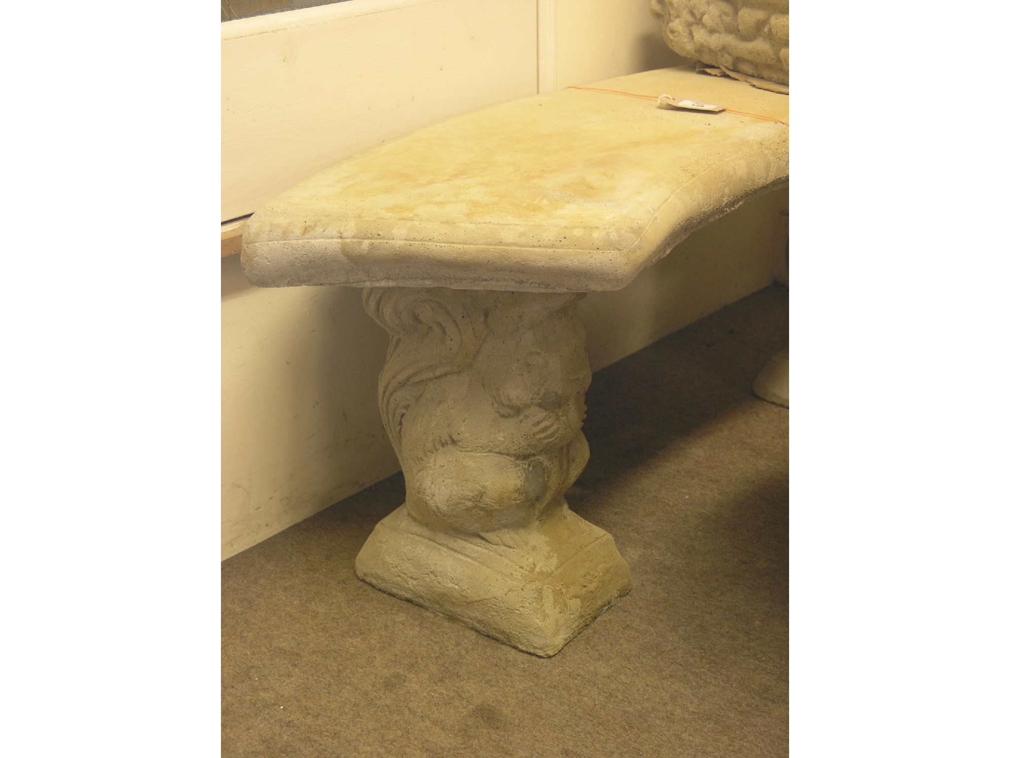 Appraisal: A moulded concrete garden seat curved twin-seater on squirrel supports