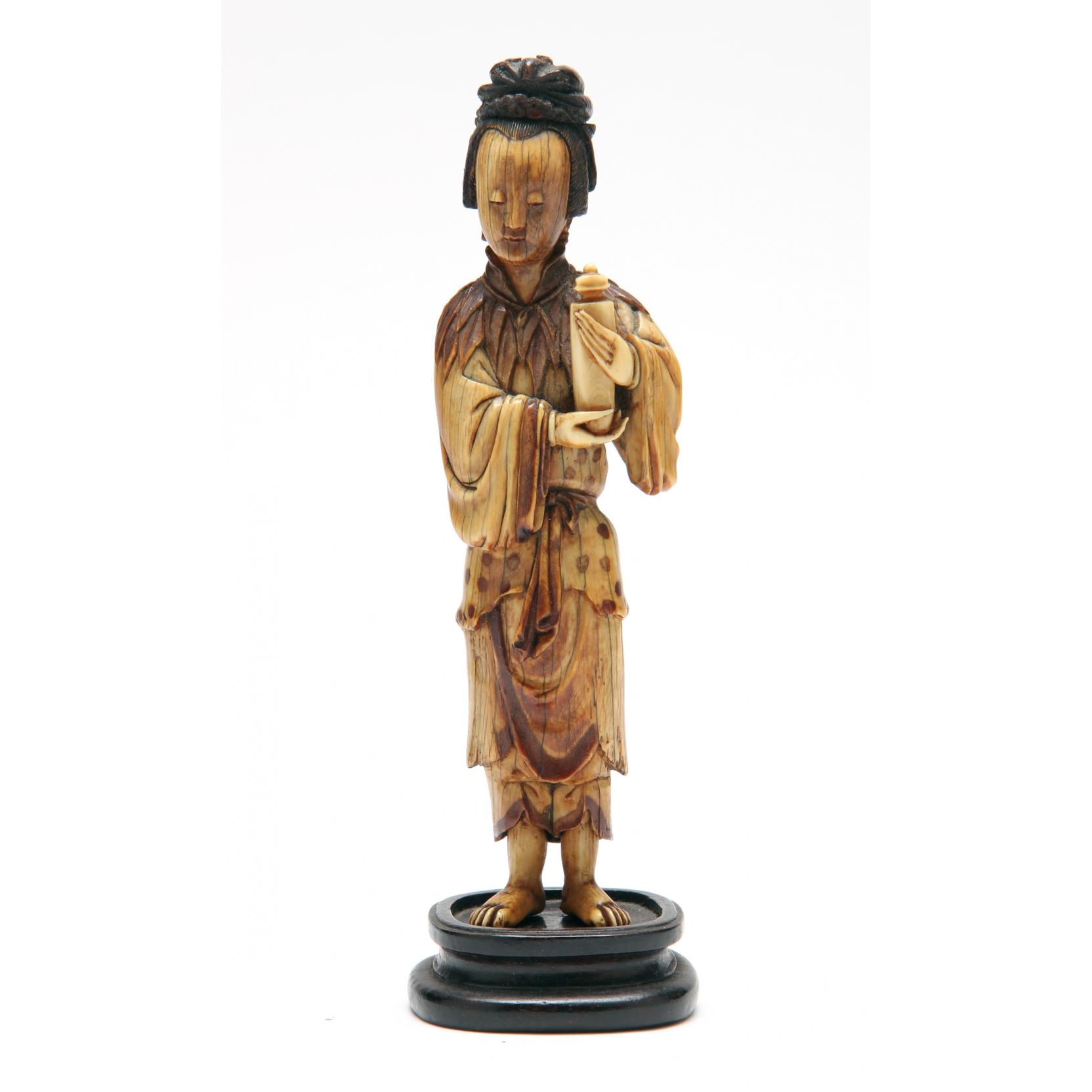 Appraisal: Chinese Stained Ivory Figure depicting a standing woman holding a