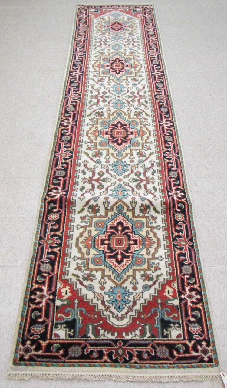 Appraisal: HAND KNOTTED ORIENTAL HALL RUG Persian Serapi design featuring four