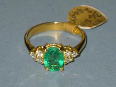 Appraisal: AN EMERALD AND DIAMOND RING having oval-cut central emerald flanked