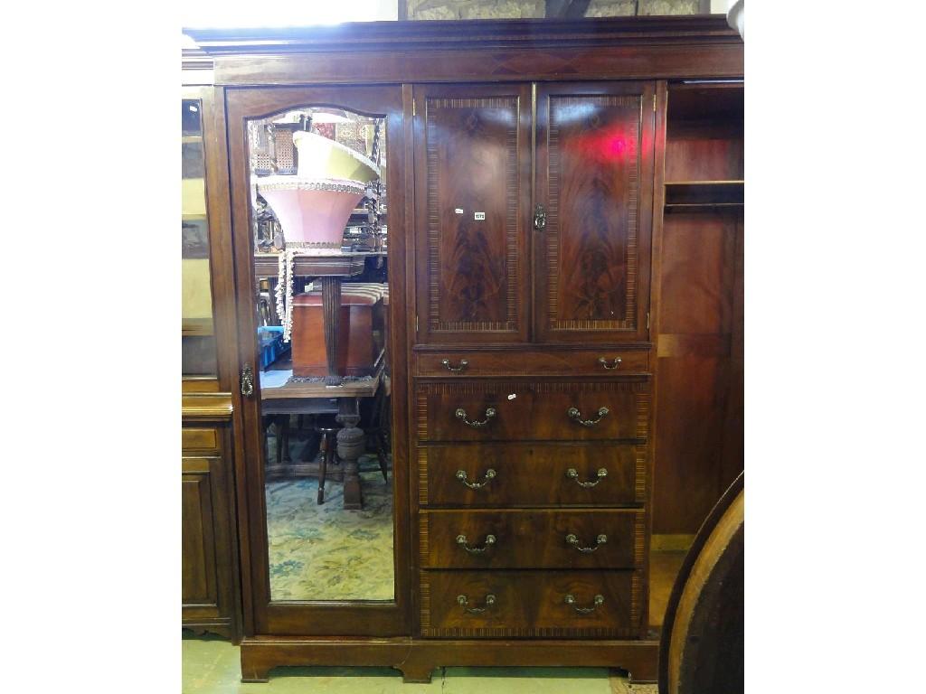 Appraisal: A substantial Edwardian mahogany triple wardrobe the centre section fitted