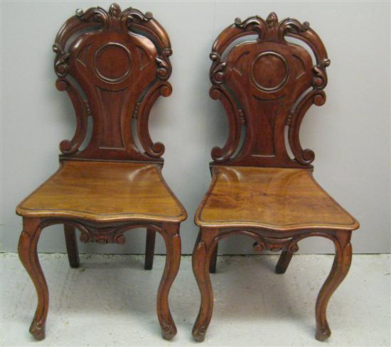 Appraisal: Pair of th century mahogany hall chairs with pierced and