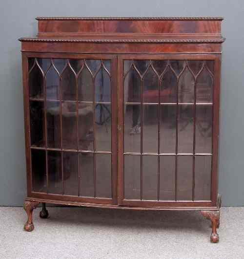 Appraisal: A s figured mahogany bow-front display cabinet with gadrooned mouldings