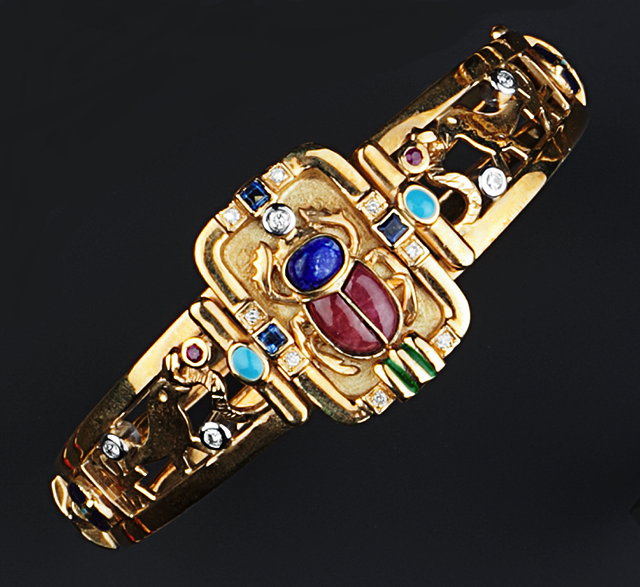 Appraisal: AN EGYPTIAN REVIVAL VARI GEM-SET AND ENAMEL SUITE comprising a